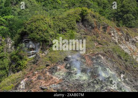 Großes geschnitztes Gesicht in Bukit Kasih, einem vulkanischen Touristenpark mit Fumarole-Feldern, einem Weltfriedenturm, Bukit Kasih, Minahasa Stockfoto