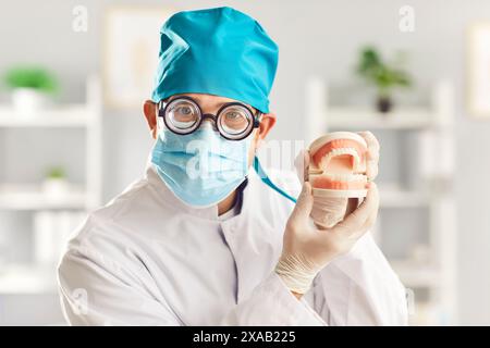 Nahaufnahme eines lustigen männlichen Zahnarztes, der in der Zahnarztklinik die Kiefer hält. Stockfoto