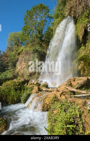 Das Bild zeigt einen Wasserfall, der eine felsige Klippe hinunterstürzt. Stockfoto