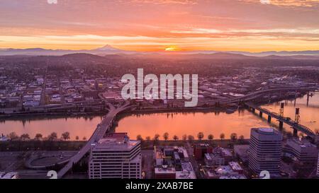 Die Sonne geht über Portland, Oregon, mit dem Willamette River und den Cascadia Mountains auf Stockfoto