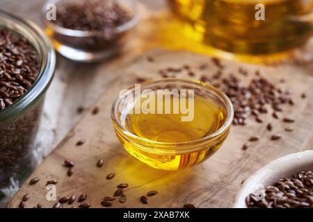 Leinsamenöl mit Leinsamen auf einem Tisch, Nahaufnahme Stockfoto