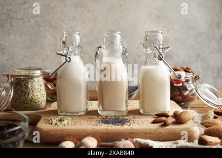 Vegane Nussmilch aus Hanfsamen, Mohn und Mandeln in drei Glasflaschen Stockfoto