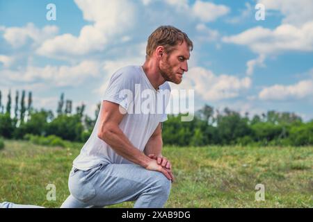 Mann Dehnt Die Beinmuskeln Im Freien Während Des Sonnentages Aus. Stockfoto