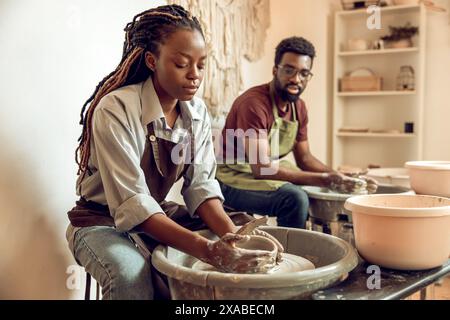 Mann und Frau, die eine Töpferwerkstatt haben und mit einbezogen sind Stockfoto