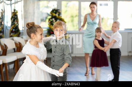 Jugendliche in eleganten Outfits üben im Weihnachtsstudio Partnertanz Stockfoto