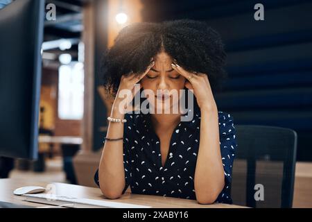 Schwarze Frau, Kopfschmerzen und Stress in der Nacht mit Angst, Depression oder Burnout im Büro. Müde Afrikanerin, weibliche Person oder junge Angestellte, die spät arbeitet Stockfoto
