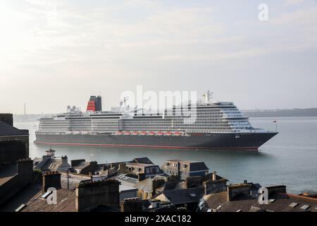 Cobh, Cork, Irland. Juni 2024. Cunards neues Kreuzfahrtschiff MS Queen Anne dampft an den Häusern am Meer vorbei, während sie auf dem Weg zum ersten Besuch des Tiefwasseranlegeplatzes in Cobh, Co. Ist. Cork, Irland. - Bild: David Creedon / Alamy Live News Stockfoto