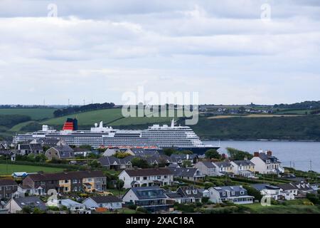 Churchbay, Cork, Irland. Juni 2024. Cunards neues Linienschiff Queen Anne segelt an Häusern am Meer vorbei, während sie zu einer Reise nach Southampton in Churchbay, Co. Cork, Irland – Bild: David Creedon / Alamy Live News Stockfoto