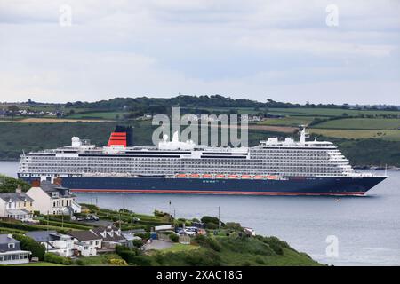 Churchbay, Cork, Irland. Juni 2024. Cunards neues Linienschiff Queen Anne segelt an Häusern am Meer vorbei, während sie zu einer Reise nach Southampton in Churchbay, Co. Cork, Irland – Bild: David Creedon / Alamy Live News Stockfoto