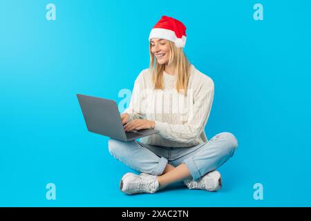 Frau sitzt auf dem Boden mit Laptop, Websurfen Stockfoto