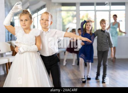Tween Mädchen und Jungs tanzen langsamen Partnertanz während festlicher Veranstaltung Stockfoto