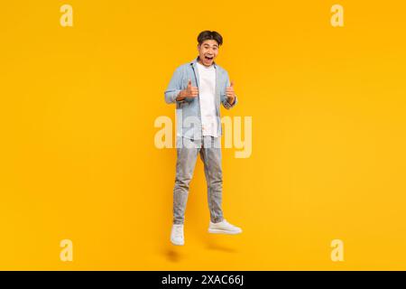 Glücklicher Mann, Der Vor Gelbem Hintergrund Springt Stockfoto