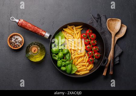 Eine lebendige Darstellung der italienischen Flagge mit Pasta, Basilikum und Tomaten, wunderschön präsentiert in einer Pfanne. Flach verlegt Stockfoto