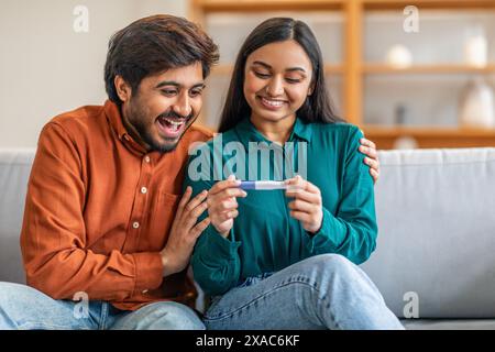 Glückliches Paar Feiert Positive Ergebnisse Des Schwangerschaftstests, Home Interior Stockfoto