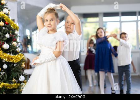 Tween Junge und Mädchen spielen Walzer während der Weihnachtsfeier in der Schule Stockfoto