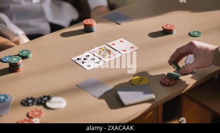 Junge Jungs spielen Poker an einem Tisch. Stockfoto