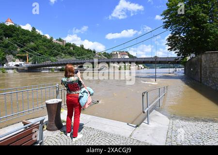 Hochwasser in Passau am 05.06.2024. Ueberflutete Uferpromenade in der Altstadt, Eien Frau fotografiert mit dem Smartphone die Donau *** Flut in Passau am 05 06 2024 überflutete Promenade in der Altstadt fotografiert eine Frau mit ihrem Smartphone die Donau Stockfoto