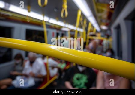 Wien, Österreich, August 2022. Aufgenommen mit verschwommenem Konzeptbild in einem U-Bahn-Auto. Die Figuren der sitzenden Personen sind zu erkennen, die gelben Stockfoto