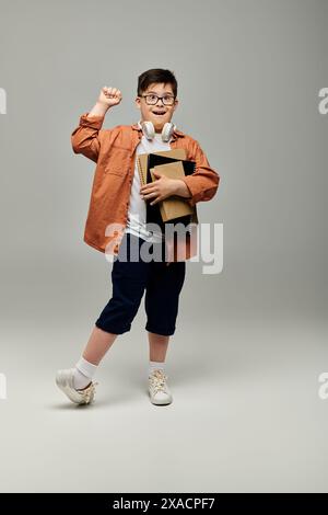 Ein kleiner Junge mit Down-Syndrom, der Bücher hält und posiert. Stockfoto