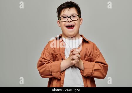 Ein kleiner Junge mit Down-Syndrom, einer Sportbrille, lächelt hell. Stockfoto