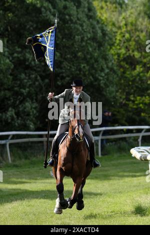 Hawick, Großbritannien. Juni 2024. Ryan Nichol trägt die ungebuschte Flagge "Banner Blue", nachdem er St. Leonards verlassen hat, galoppiert er "Roond the Mair", bevor er vor dem zeremoniellen Beginn des Common Riding in der Stadt Dienst nimmt. Später heute, Donnerstag, den 06. Juni 2024, ist Hawick Common Riding die erste der jährlichen Grenzveranstaltungen. es feiert die Gefangennahme einer englischen Flagge von einer Raidparty im Jahr 1514 durch die Jugend von Hawick in Hornshole und den alten Brauch, auf den Märschen oder Grenzen des gemeinsamen Landes zu reiten. Quelle: Rob Gray/Alamy Live News Stockfoto