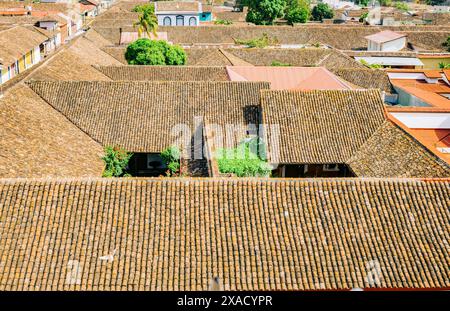 Blick auf die gekachelten Dächer der farbenfrohen Gebäude in Granada, Nicaragua. Blick von oben auf die Fassade der farbenfrohen Kolonialgebäude in der Stadt Granada Stockfoto