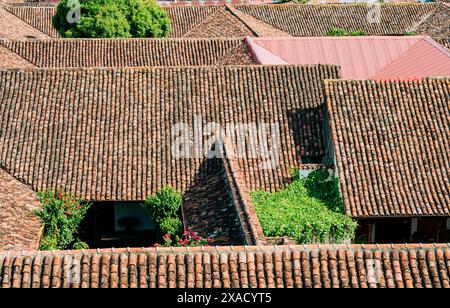 Blick von oben auf alte Terrakottafliesen auf dem Dach einiger Häuser. Alte Ziegeldächer von Häusern in Granada, Nicaragua Stockfoto