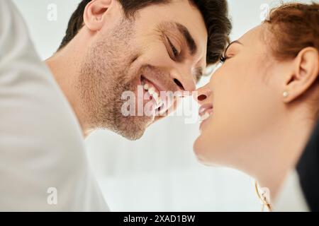 Ein Mann küsst ein Frauengesicht liebevoll, während sie vor Freude lächelt und einen Moment tiefer Zuneigung und Glück zeigt. Stockfoto