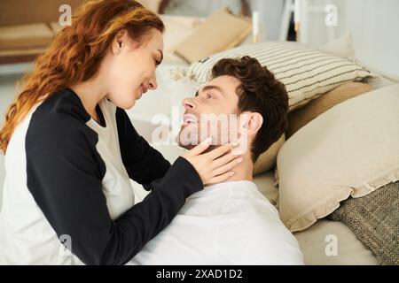 Ein Mann und eine Frau ruhen sich friedlich auf einem Bett aus, in die Arme gewickelt, und genießen intime Momente miteinander. Stockfoto