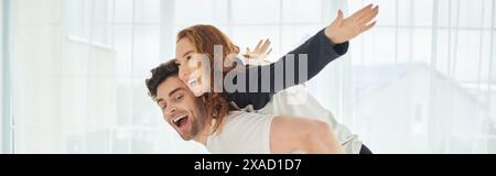 Ein Mann, der eine Frau auf dem Rücken unterstützt und Stärke und Einheit in ihrer Beziehung zeigt, während sie Zeit miteinander verbringen. Stockfoto