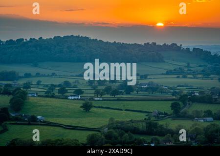 Wunderschöner Sonnenuntergang auf der englischen Landschaft in der Nähe von Batcombe in Dorset County, untergehende Sonne und dramatische Wolken über den Hügeln und Ackerland Stockfoto