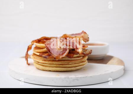 Leckere Pfannkuchen mit Speck und Honig auf weißem Tisch, Nahaufnahme Stockfoto