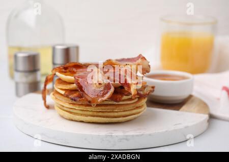 Leckere Pfannkuchen mit Speck und Honig auf weißem Tisch, Nahaufnahme Stockfoto