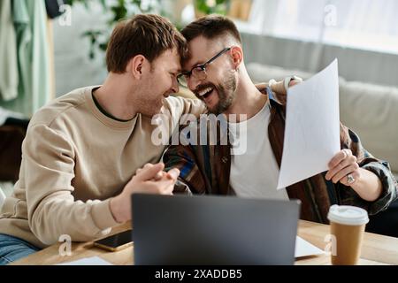 Zwei Männer in der Designerwerkstatt arbeiten zusammen an einem Laptop Stockfoto