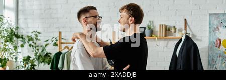 Zwei Männer in einer Designerwerkstatt, die modische Kleidung mit einem Hauch von Liebe und Kreativität herstellen. Stockfoto