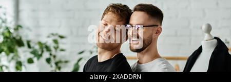 Zwei Männer, Mitglieder eines schwulen Paares, stehen Seite an Seite in einer Designerwerkstatt und arbeiten an der Gestaltung trendiger Kleidung. Stockfoto