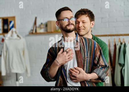 Zwei Männer umarmen sich, während sie zusammen im Atelier stehen Stockfoto