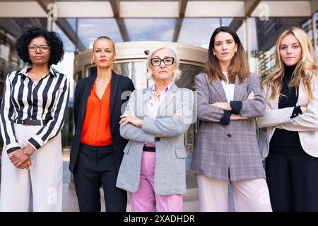 Multirassische Geschäftsfrauen, angeführt vom Boss, geben sich ernsthaft für die Kamera aus. Stockfoto