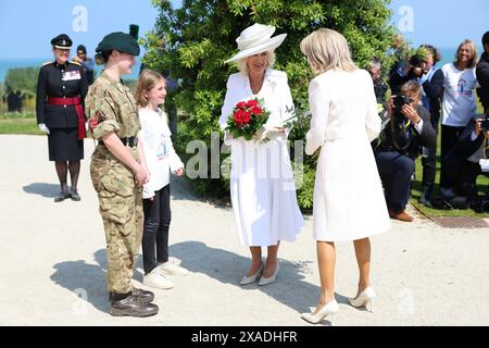 Königin Camilla (Mitte) und Brigitte Macron erhalten Blumensträuße, die im Anschluss an die britische nationale Gedenkfeier zum 80. Jahrestag des D-Day in Ver-sur-Mer, Normandie, Frankreich liegen. Bilddatum: Donnerstag, 6. Juni 2024. Stockfoto