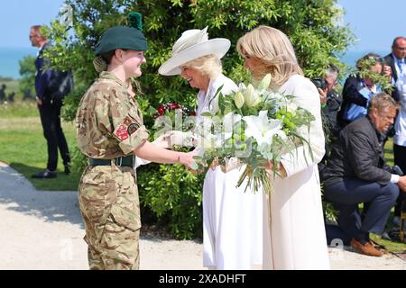 Königin Camilla (Mitte) und Brigitte Macron erhalten Blumensträuße, die im Anschluss an die britische nationale Gedenkfeier zum 80. Jahrestag des D-Day in Ver-sur-Mer, Normandie, Frankreich liegen. Bilddatum: Donnerstag, 6. Juni 2024. Stockfoto