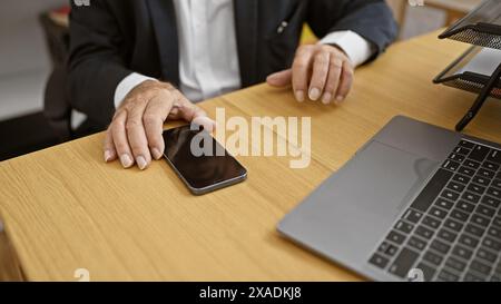 Elegante Hände eines älteren Mannes bei der Arbeit, ein erfahrener Geschäftsmann, der am Bürotisch sitzt und am Computer im Herzen von Indoor-Profis Magie macht Stockfoto