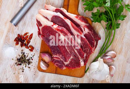 Rohes Rindfleisch mit Petersilie, Zwiebeln, Knoblauch und Gewürzen Stockfoto