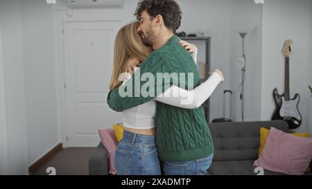 Ein liebevolles Paar umarmt sich herzlich in der gemütlichen, modernen Einrichtung ihrer Wohnung und vermittelt ein Gefühl von Intimität und Gesellschaft. Stockfoto