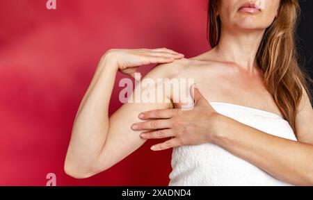 Postoperative Narbe auf der Schulter einer Frau. Eine Frau zeigt die Narbe. Narbe nach Operation nach gebrochenem Armknochen. Stockfoto