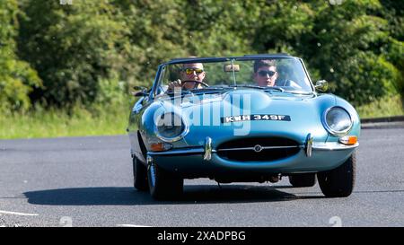 Stony Stratford, UK - 2. Juni 2024: Klassischer britischer Jaguar E-Typ 1967, der auf einer britischen Landstraße fährt Stockfoto