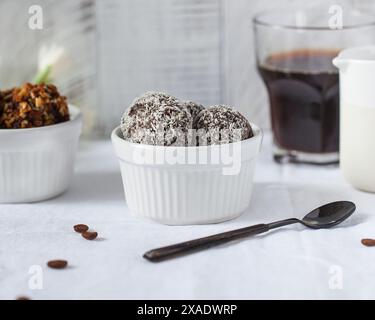 Stellen Sie Schokoladenbonbons mit Kokosflocken in einer Keramikschale her Stockfoto