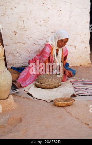 Berberfrau im Troglodyte House Grinding Corn, Matmata, Gabes Governorate, Tunesien Stockfoto