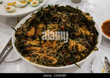 Traditionelle chinesische Speisen Gourmet-Mahlzeit oder lokale Küche Kulturstamm Stir gebratene Nudeln Wakame Seetang mit Sichuan Pfeffer Chili Paste servieren Kunden Stockfoto