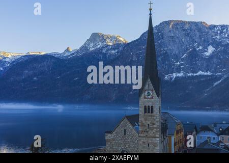 Fotografie der österreichischen Kleinstadt Hallstatt an einem nebeligen Bergseeufer Stockfoto