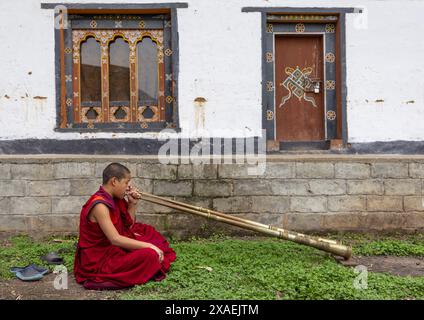 Bhutanische Novizen Mönche spielen Hörner in Nyenzer Lhakhang, Thedtsho Gewog, Wangdue Phodrang, Bhutan Stockfoto